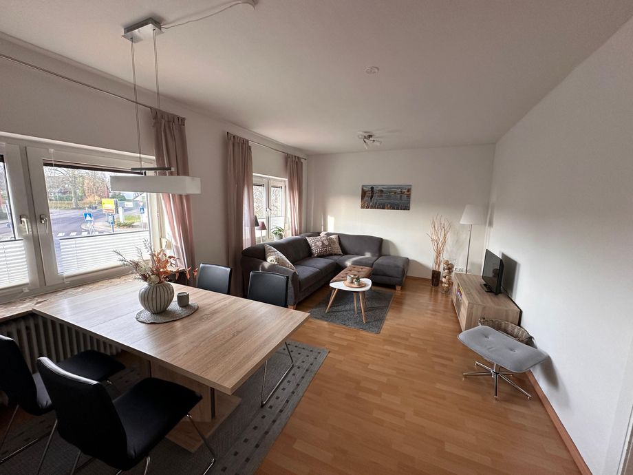 Wohnzimmer der Ferienwohnung Sommerzeit mit Esstisch, Sofa und TV